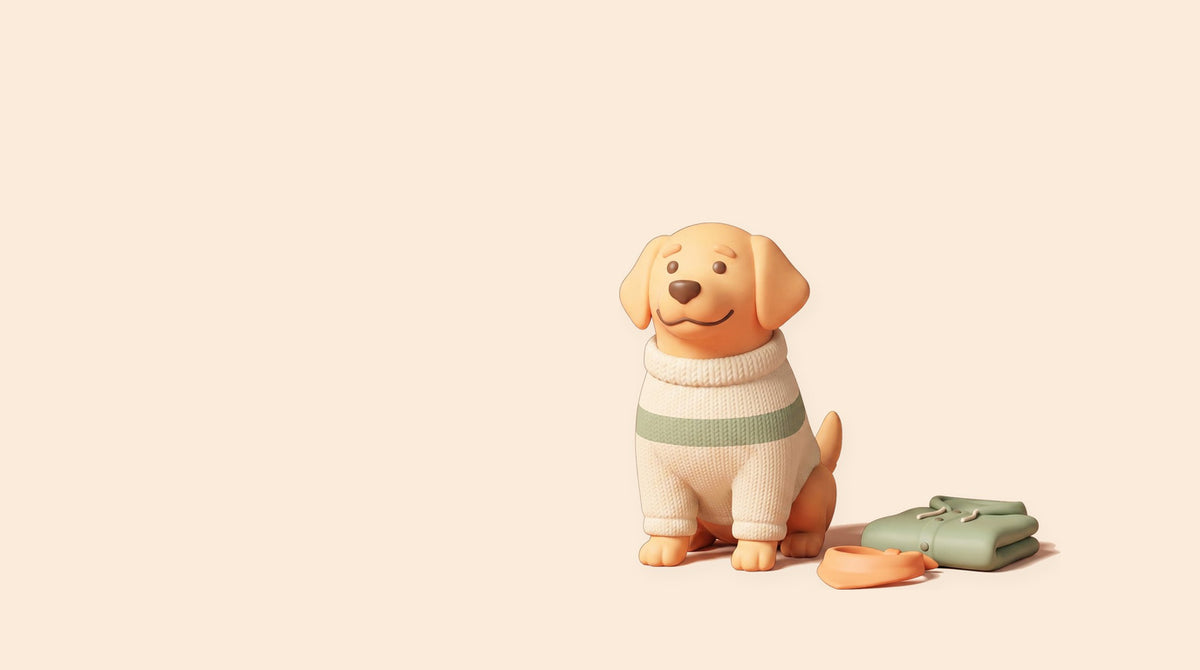 A golden retriever sitting in a cream and green knitted jumper, with folded clothes beside it.