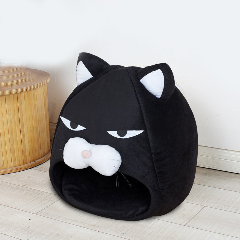 Black cat-shaped pet bed with white face and eyes on a light wooden floor.