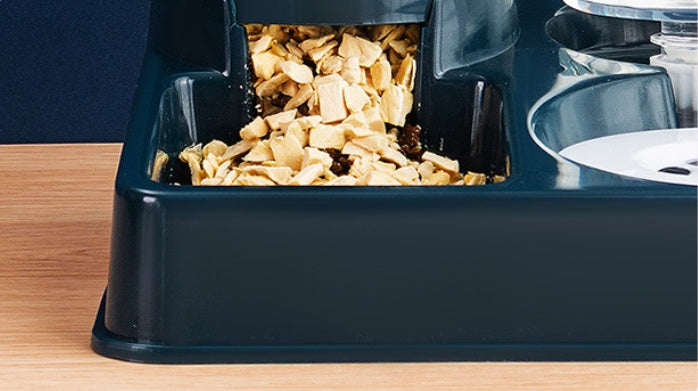 Navy blue pet food dispenser with pet food on a wooden surface