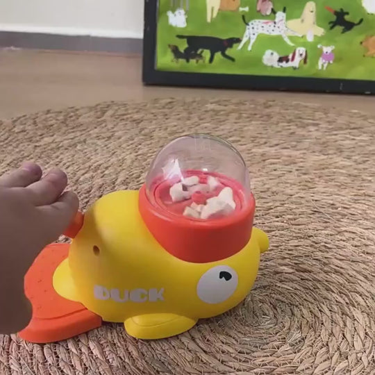 dog paw pressing yellow duck puzzle feeder releasing treats slow kibble dispense interactive to