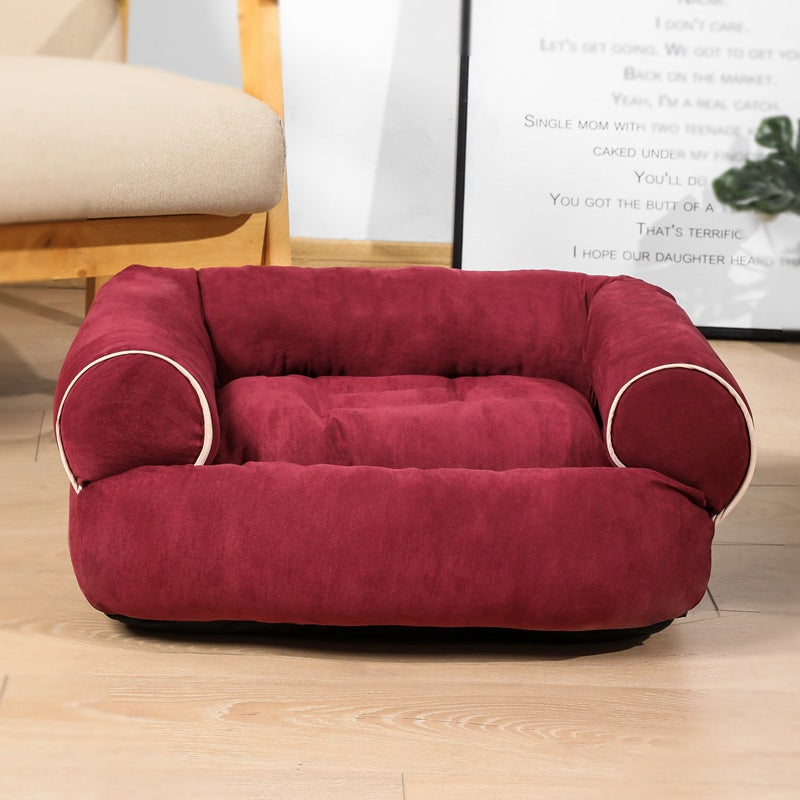 Red pet bed on a wooden floor with a blurred background